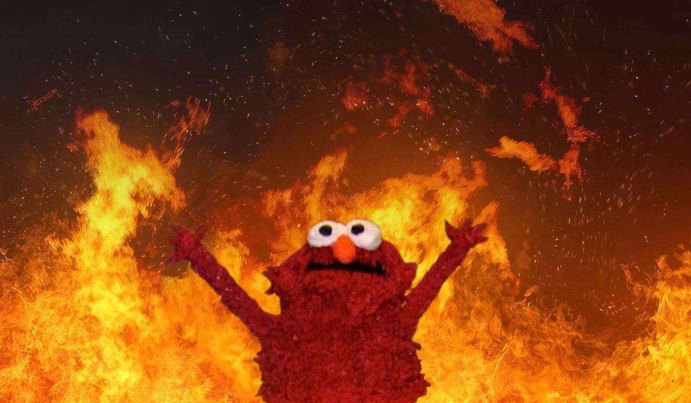 Meme do Elmo de braços erguidos em meio às chamas
