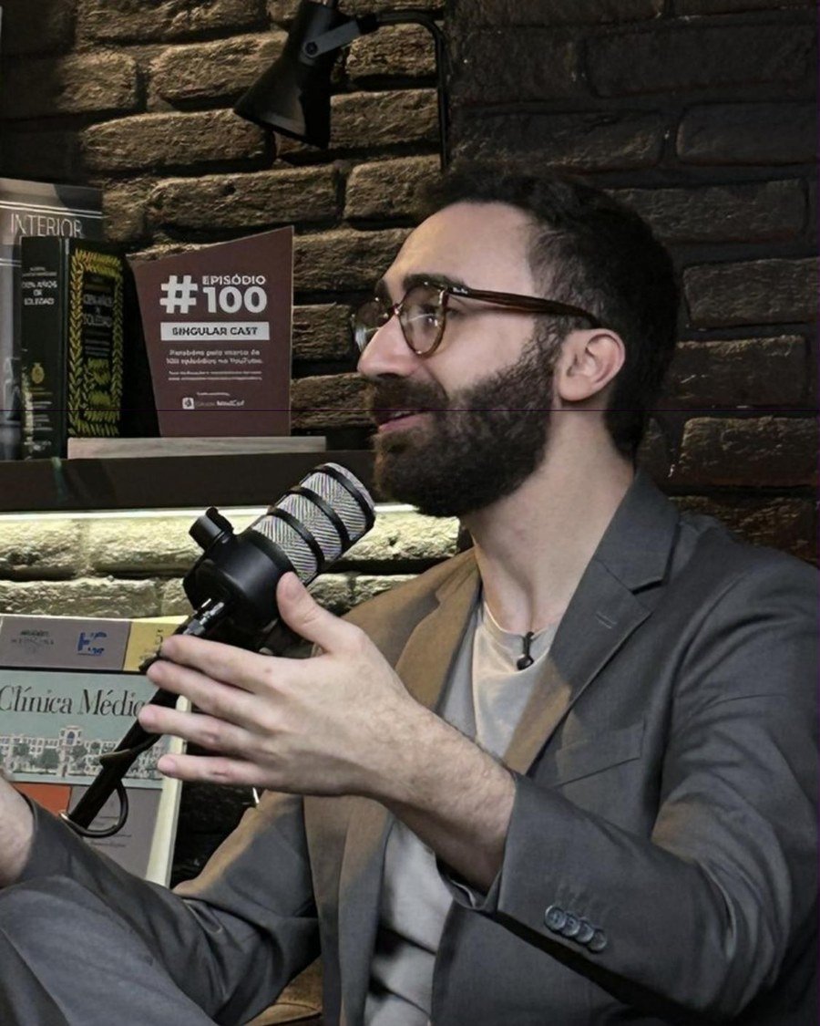 Mateus Cavarzan falando ao microfone durante gravação do Singular Cast